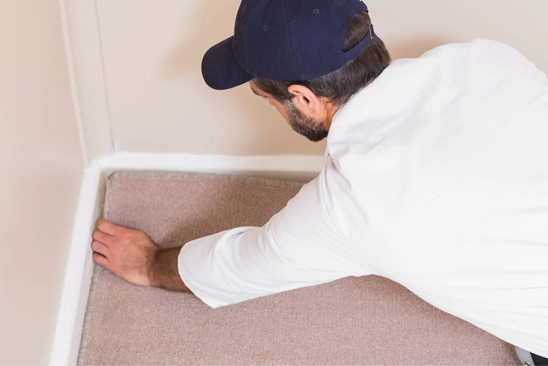 Handwerker entfernt Teppichboden in einer Zimmerecke